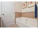 Bathroom featuring a large bathtub and tile flooring at 11948 Palm Bay Ct, New Port Richey, FL 34654