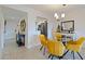 Dining area with glass top table and yellow chairs, near entryway at 1316 Pasadena S Ave # 203, South Pasadena, FL 33707