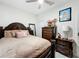 Bedroom with ceiling fan, dark wood furniture, and neutral bedding at 19212 Sunlake Blvd, Lutz, FL 33558