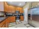 Kitchen with wood cabinets, stainless steel appliances, and a large refrigerator at 19538 Timberbluff Dr, Land O Lakes, FL 34638