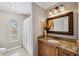 Bathroom featuring a decorative framed mirror, granite countertops, and a combined tub and shower at 224 7Th E St, Tierra Verde, FL 33715