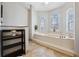 Relaxing bathroom featuring a large soaking tub with a view from the arched windows at 224 7Th E St, Tierra Verde, FL 33715