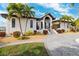 Stunning exterior with a stone driveway, lush landscaping, and an elegant entrance, creating an inviting curb appeal at 224 7Th E St, Tierra Verde, FL 33715