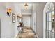 Hallway featuring neutral paint, decorative sconces, stone tile, and a decorative table at 224 7Th E St, Tierra Verde, FL 33715