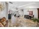 Open-concept living and dining area with stone floors, high ceilings, and natural light from poolside windows at 224 7Th E St, Tierra Verde, FL 33715