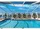 Covered pool area featuring a large pool surrounded by potted trees and views of the water at 224 7Th E St, Tierra Verde, FL 33715