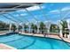 Waterfront screened pool features clear water, lush decor, and a serene view, ideal for relaxation and entertaining at 224 7Th E St, Tierra Verde, FL 33715