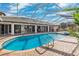 Outdoor swimming pool with screened enclosure, brick-paver deck, and views of the back of the house at 224 7Th E St, Tierra Verde, FL 33715