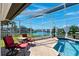 Beautifully screened-in pool with a waterfront view, patio seating, and lush landscaping at 224 7Th E St, Tierra Verde, FL 33715