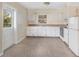 White kitchen cabinets, speckled floor, and appliances at 2418 N Links Ave, Sarasota, FL 34234