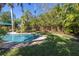 Large grassy backyard with a pool and mature trees at 323 Coffee Pot Ne Dr, St Petersburg, FL 33704