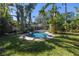 Tropical backyard paradise with a pool and lush green lawn at 323 Coffee Pot Ne Dr, St Petersburg, FL 33704