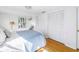 Bedroom featuring hardwood floors, white closet doors, and ample natural light at 323 Coffee Pot Ne Dr, St Petersburg, FL 33704