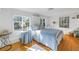 Bright bedroom with hardwood floors, white walls, and two large windows at 323 Coffee Pot Ne Dr, St Petersburg, FL 33704