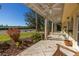 Covered patio with a wooden rocking chair overlooking a landscaped yard and water view at 323 Coffee Pot Ne Dr, St Petersburg, FL 33704