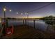 Dock with kayak, seating, and string lights at twilight at 323 Coffee Pot Ne Dr, St Petersburg, FL 33704