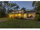 Exterior of a home on a corner lot, illuminated at twilight, highlighting its architecture at 323 Coffee Pot Ne Dr, St Petersburg, FL 33704