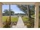Landscaped front yard with palm trees, a paved walkway, and a distant view of the water at 323 Coffee Pot Ne Dr, St Petersburg, FL 33704