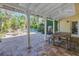 Covered patio with outdoor dining area overlooking a pool and tropical landscaping at 323 Coffee Pot Ne Dr, St Petersburg, FL 33704