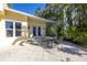 Patio with outdoor furniture set against the backdrop of a yellow house and palm trees at 323 Coffee Pot Ne Dr, St Petersburg, FL 33704