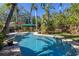 Spacious backyard with a pool surrounded by lush tropical foliage at 323 Coffee Pot Ne Dr, St Petersburg, FL 33704