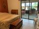 Bedroom with sliding glass doors to screened porch with outdoor furniture at 3480 Hillmoor Dr, Palm Harbor, FL 34685