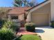 Front view of charming condo with red tile roof, attached garage, and landscaped walkway at 3480 Hillmoor Dr, Palm Harbor, FL 34685