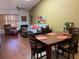 Open living and dining area with hardwood floors, comfortable seating, and large windows at 3480 Hillmoor Dr, Palm Harbor, FL 34685