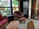 Comfortable sunroom with wicker furniture, natural light, and views of the surrounding landscape at 3480 Hillmoor Dr, Palm Harbor, FL 34685