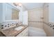 Bathroom with beige tile, bathtub, and granite countertop vanity at 514 Ryans Woods Ln, Palm Harbor, FL 34683