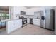 Modern white kitchen with stainless steel appliances and granite countertops at 514 Ryans Woods Ln, Palm Harbor, FL 34683