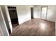 Open bedroom space with wood-look floors, an access door, and a view into an adjacent room at 7424 Lance St, Zephyrhills, FL 33541