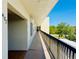 A long hallway with a black railing and view of trees outside at 8198 Terrace Garden N Dr # 407, St Petersburg, FL 33709