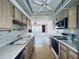 Galley kitchen with wood cabinets, white countertops, ceiling fans and modern appliances at 8198 Terrace Garden N Dr # 407, St Petersburg, FL 33709