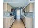 Galley kitchen with light wood cabinets, white countertops, and modern appliances at 8198 Terrace Garden N Dr # 407, St Petersburg, FL 33709