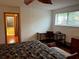 Spacious bedroom with a ceiling fan, a desk with chair, and outside views through a window at 10 Woodridge Cir, Oldsmar, FL 34677