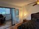 Bright bedroom with a view of the patio, featuring a king-size bed and workspace at 10 Woodridge Cir, Oldsmar, FL 34677
