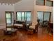 Living room with hardwood floors, large windows, and access to a sunroom and dining area at 10 Woodridge Cir, Oldsmar, FL 34677