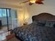 Inviting main bedroom featuring a textured headboard, ceiling fan, and balcony access at 10 Woodridge Cir, Oldsmar, FL 34677