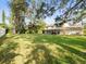 Spacious backyard with lush green lawn, mature trees, and white fence at 10114 Lindelaan Dr, Tampa, FL 33618