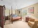Bedroom featuring a four-poster bed, carpeted floors, and matching wood furniture at 10114 Lindelaan Dr, Tampa, FL 33618