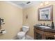 Elegant half bathroom with a dark wood vanity, granite countertop, and ornate mirror at 10114 Lindelaan Dr, Tampa, FL 33618