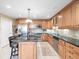 Modern kitchen boasts stainless steel appliances, ample wood cabinetry, and a granite island with seating at 10114 Lindelaan Dr, Tampa, FL 33618