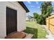 Backyard access with wooden steps and black door, offering ample green space at 102 Shore E Dr, Oldsmar, FL 34677