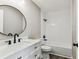 Updated bathroom features a new white vanity, dark hardware and shower-tub combination at 102 Shore E Dr, Oldsmar, FL 34677