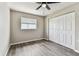 Bright bedroom features a ceiling fan, wood-look floors, a window and closet at 102 Shore E Dr, Oldsmar, FL 34677
