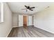 Bedroom features a ceiling fan, wood-look floors, and an entrance to an adjoining room at 102 Shore E Dr, Oldsmar, FL 34677