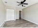 Bedroom features ceiling fan, wood-look floors, and an entrance to an adjoining room at 102 Shore E Dr, Oldsmar, FL 34677