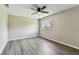 This bedroom features a ceiling fan, a window, and wood-look floors at 102 Shore E Dr, Oldsmar, FL 34677