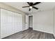 This bedroom offers a ceiling fan, spacious closet, and wood-look floors at 102 Shore E Dr, Oldsmar, FL 34677